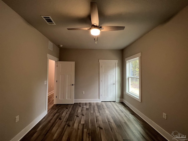 unfurnished bedroom with ceiling fan and dark hardwood / wood-style flooring