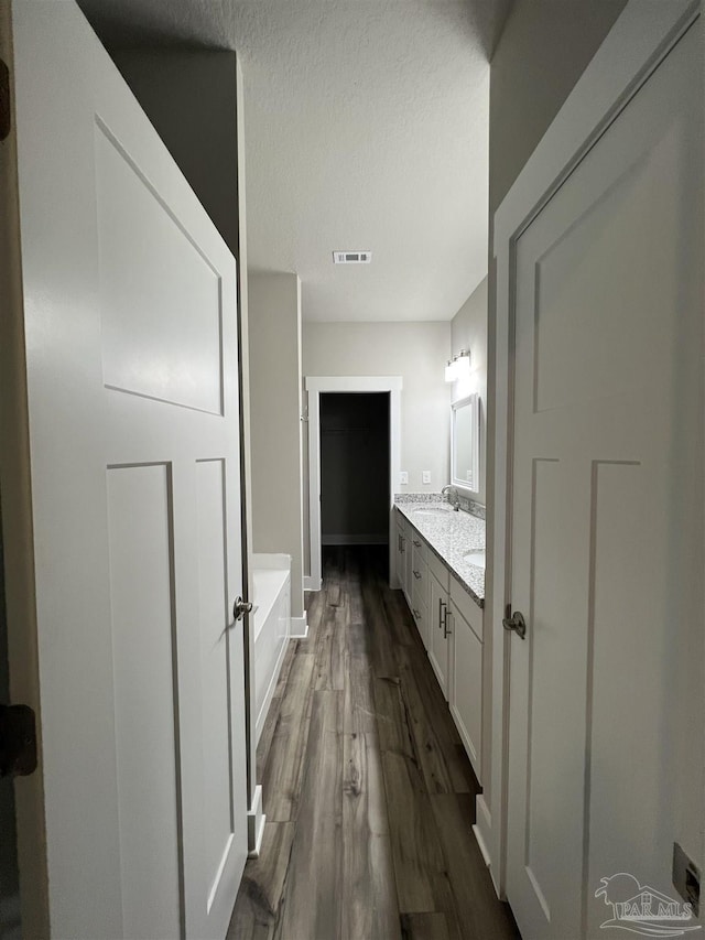 bathroom with hardwood / wood-style flooring, vanity, and a bathtub