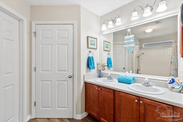 bathroom featuring a shower, hardwood / wood-style floors, and vanity