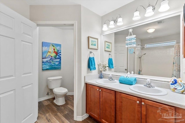 bathroom featuring walk in shower, hardwood / wood-style floors, vanity, and toilet