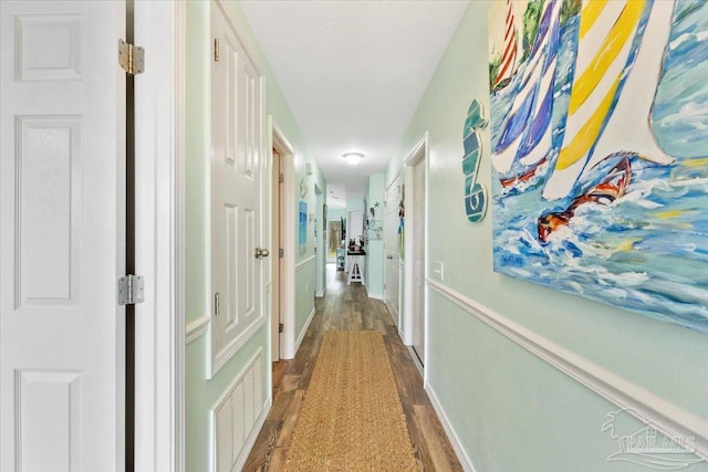 corridor with dark hardwood / wood-style flooring