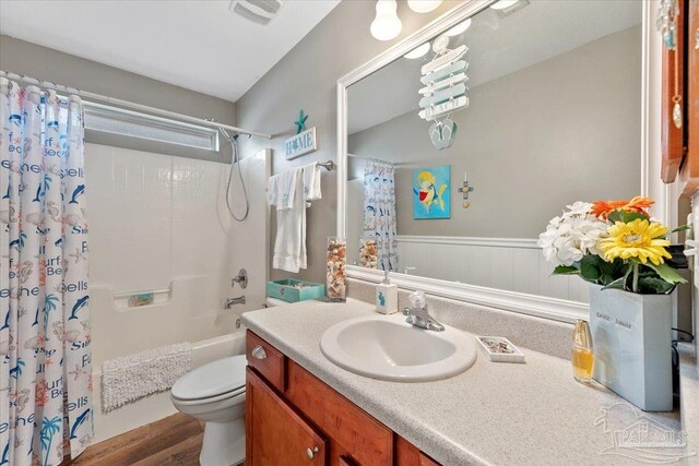 full bathroom with shower / bath combination with curtain, vanity, hardwood / wood-style flooring, and toilet