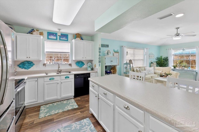 kitchen with sink, appliances with stainless steel finishes, dark wood-type flooring, and plenty of natural light