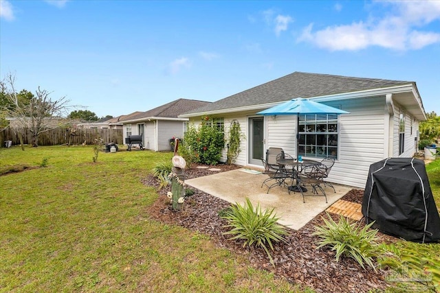 back of house featuring a lawn and a patio area