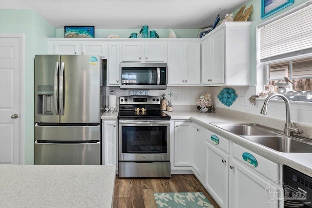 kitchen with stainless steel appliances, white cabinetry, dark wood-type flooring, and sink