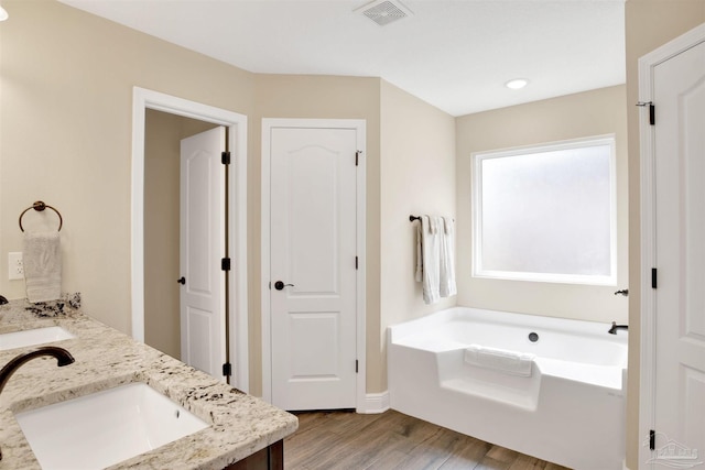 2956 N 17th Ave, Milton, FL 32583 - full bath featuring a bath, wood finished floors, double vanity, and baseboards