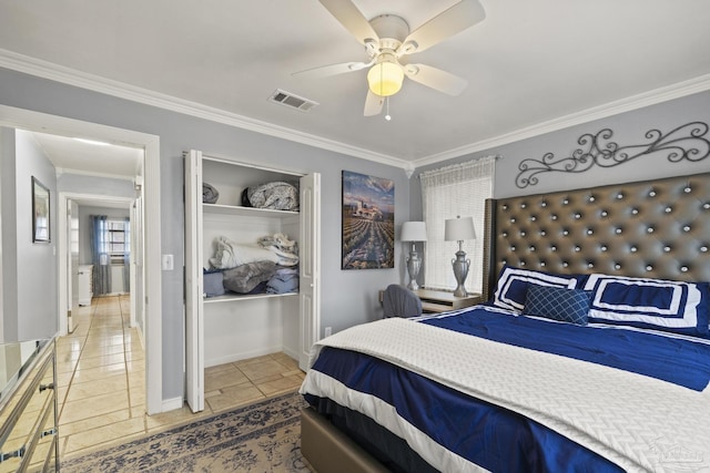 tiled bedroom with ornamental molding, ceiling fan, and a closet