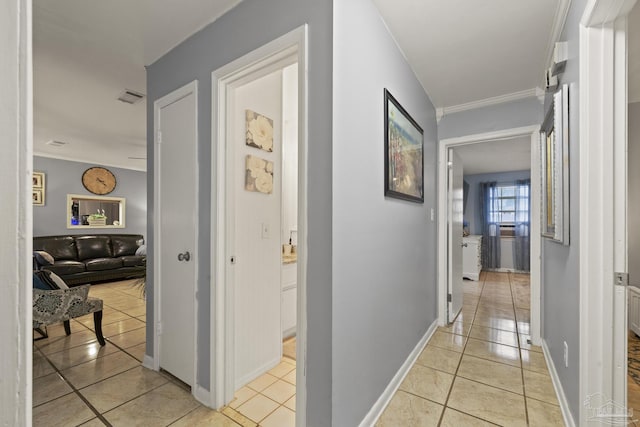 corridor with crown molding and light tile patterned floors