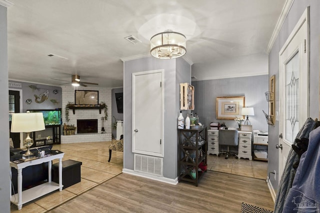 living room with a brick fireplace, hardwood / wood-style flooring, and ornamental molding