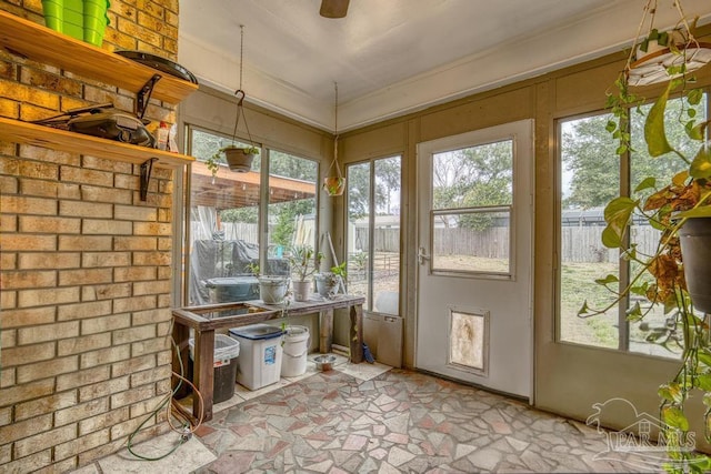 unfurnished sunroom featuring ceiling fan