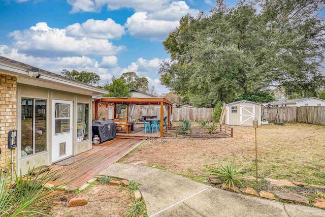 view of yard with a gazebo, a storage unit, and a deck