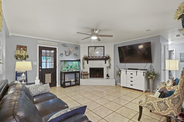 tiled living room featuring crown molding, ceiling fan, and a brick fireplace