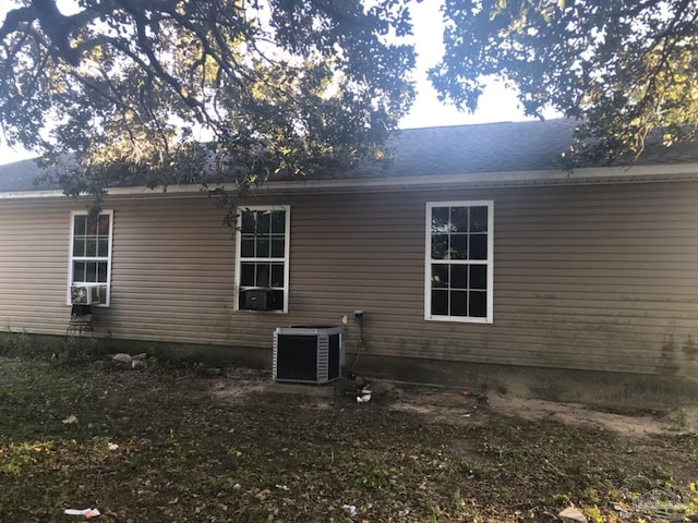 rear view of property with central AC and cooling unit