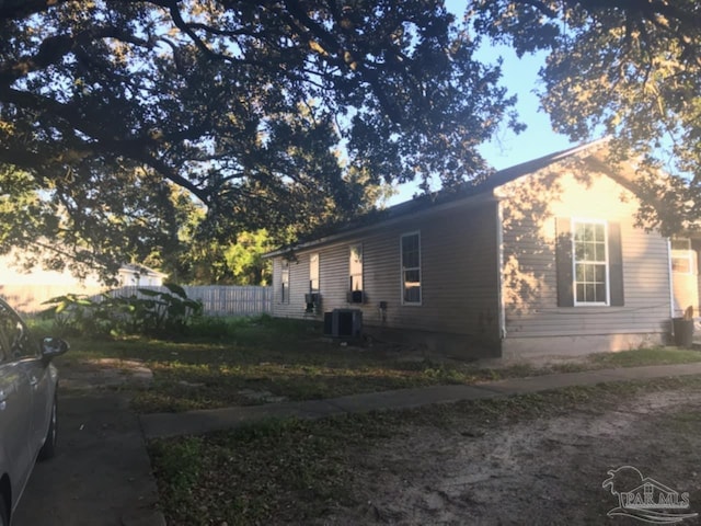 view of home's exterior featuring central air condition unit and fence