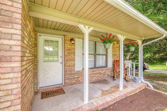 view of exterior entry featuring covered porch