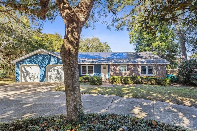 ranch-style house with a garage and solar panels