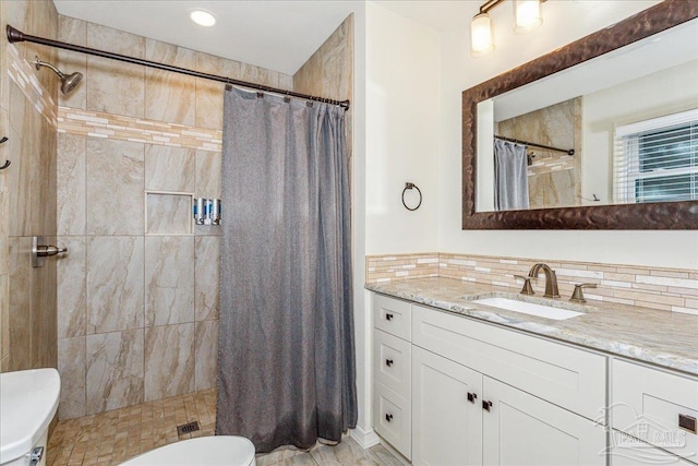 bathroom with toilet, vanity, backsplash, and curtained shower