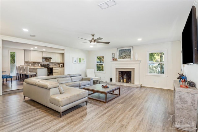 living room with ceiling fan and light wood-type flooring