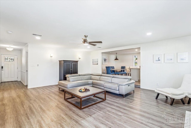 living room with light wood-type flooring and ceiling fan