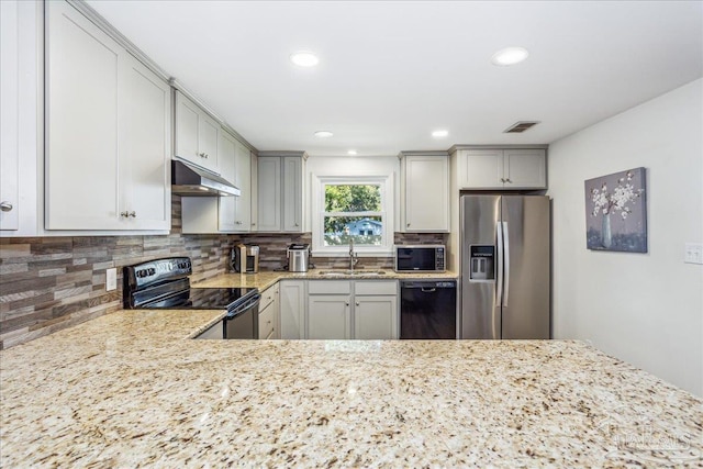 kitchen with black appliances, tasteful backsplash, sink, kitchen peninsula, and light stone counters