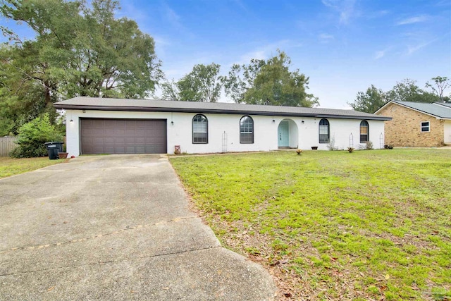 ranch-style home with a garage and a front lawn