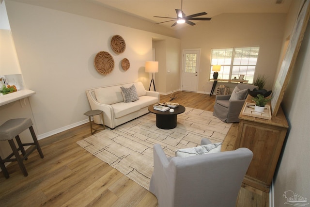 living room featuring lofted ceiling, baseboards, a ceiling fan, and wood finished floors