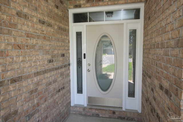 entrance to property featuring brick siding