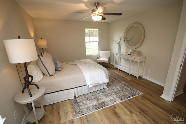 bedroom with baseboards, a ceiling fan, and wood finished floors