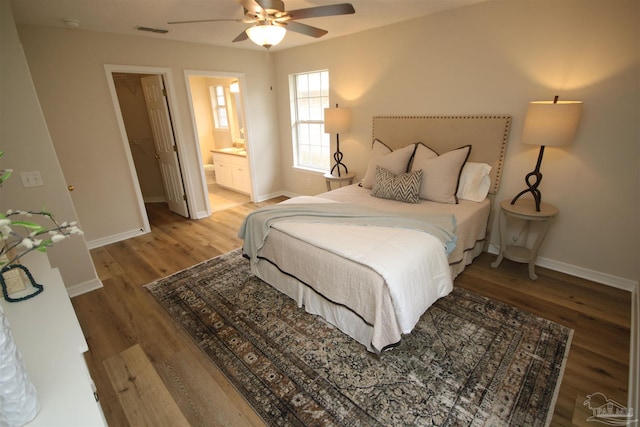 bedroom featuring visible vents, baseboards, a ceiling fan, light wood-style floors, and ensuite bath