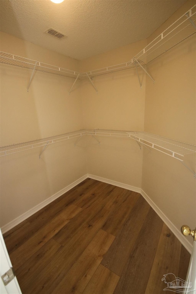 walk in closet featuring wood finished floors and visible vents