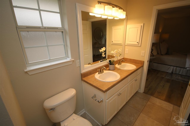 ensuite bathroom featuring toilet, a sink, connected bathroom, and tile patterned flooring