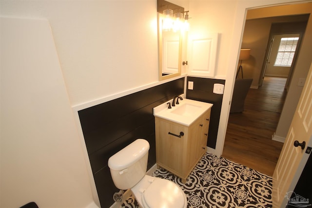 bathroom with vanity, toilet, and wood finished floors
