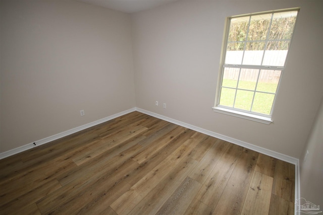 spare room featuring baseboards and hardwood / wood-style floors