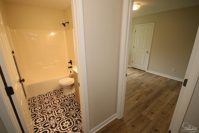 full bathroom featuring toilet, baseboards, shower / bathing tub combination, and wood finished floors