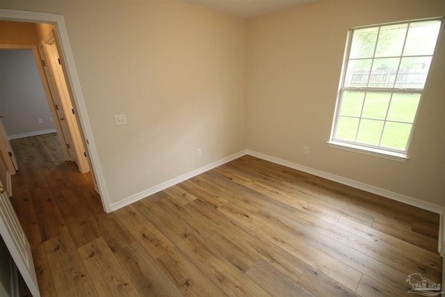 unfurnished room with hardwood / wood-style floors and baseboards