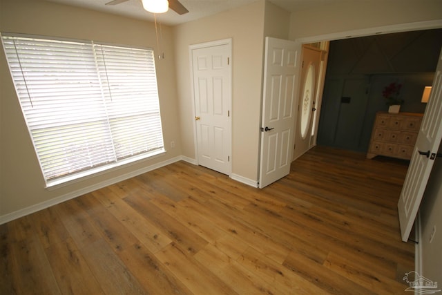 unfurnished bedroom with baseboards, a ceiling fan, and wood finished floors