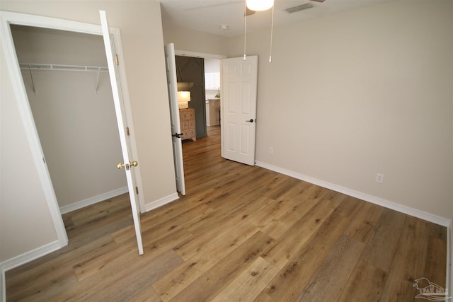 unfurnished bedroom with ceiling fan, light wood finished floors, baseboards, and visible vents
