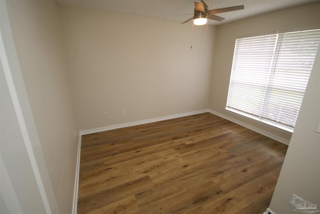unfurnished room with ceiling fan, wood finished floors, and baseboards