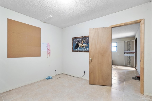 921 Candlestick Dr, Pensacola, FL 32514 - unfurnished room with a textured ceiling, light tile patterned floors, and baseboards