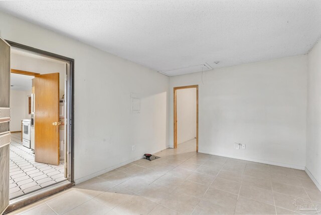 921 Candlestick Dr, Pensacola, FL 32514 - spare room featuring attic access, light tile patterned flooring, and a textured ceiling