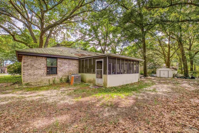 921 Candlestick Dr, Pensacola, FL 32514 - view of side of home featuring a sunroom, central AC, and brick siding