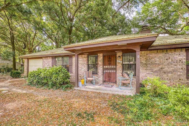 921 Candlestick Dr, Pensacola, FL 32514 - view of front facade featuring brick siding, an attached garage, a chimney, and covered porch