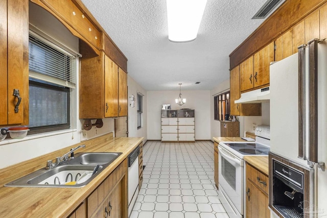 921 Candlestick Dr, Pensacola, FL 32514 - kitchen with white appliances, under cabinet range hood, light countertops, a sink, and a textured ceiling