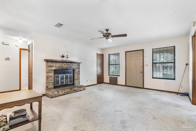 921 Candlestick Dr, Pensacola, FL 32514 - unfurnished living room with plenty of natural light, a textured ceiling, a ceiling fan, carpet, and a fireplace
