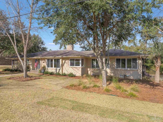 ranch-style home with crawl space, brick siding, a chimney, and a front lawn