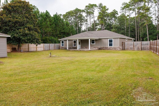 9317 Alekai Dr, Pensacola, FL 32526 - back of house with a fenced backyard and board and batten siding