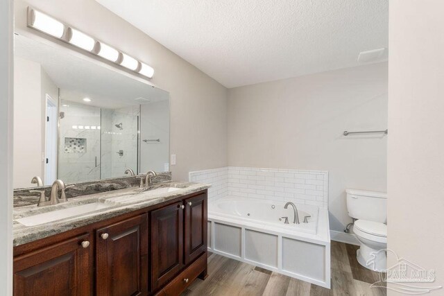 9317 Alekai Dr, Pensacola, FL 32526 - bathroom featuring a shower stall, wood finished floors, a tub with jets, double vanity, and a textured ceiling