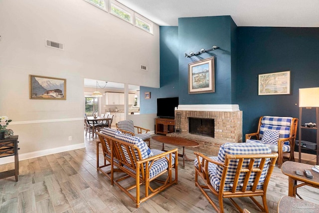 8150 Northpointe Blvd, Pensacola, FL 32514 - living room with light wood-type flooring, a high ceiling, a fireplace, and baseboards