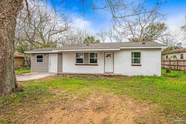 ranch-style home featuring a front lawn and fence