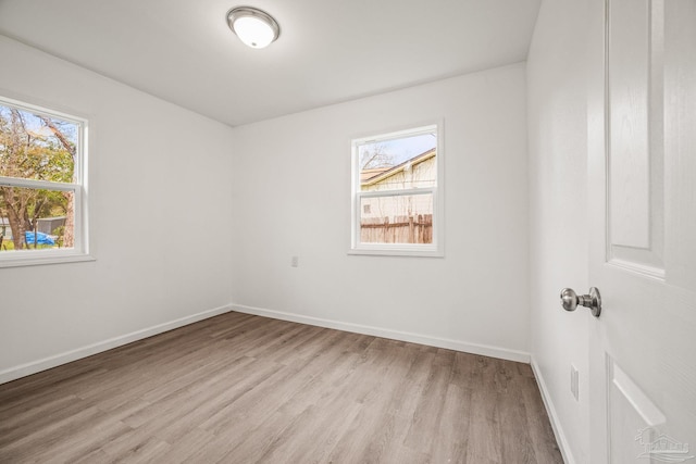 empty room featuring light wood-type flooring and baseboards